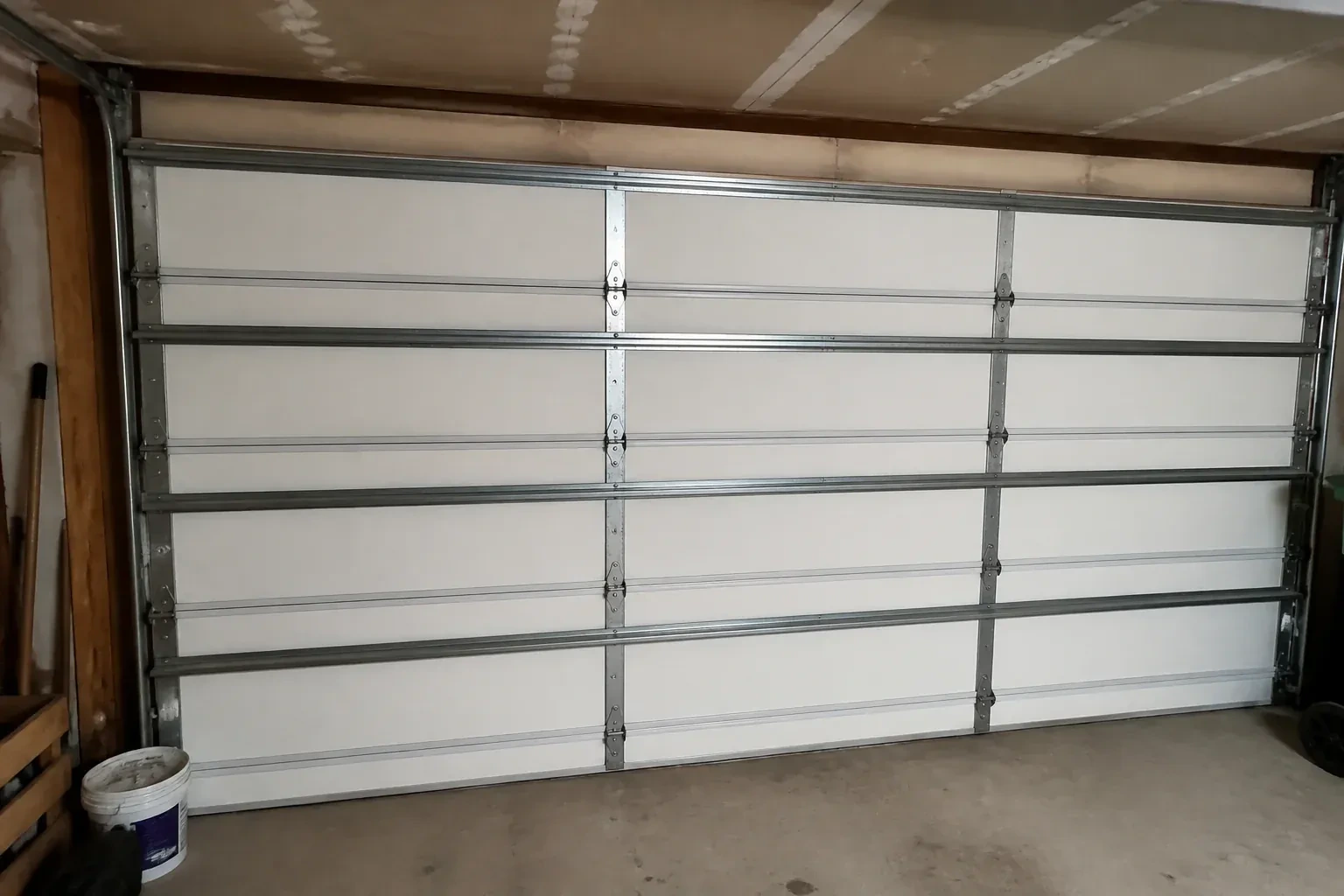 Interior of a closed sectional door with horizontal metal reinforcement struts. — Wind-Rated Garage Door Replacement, Whitby